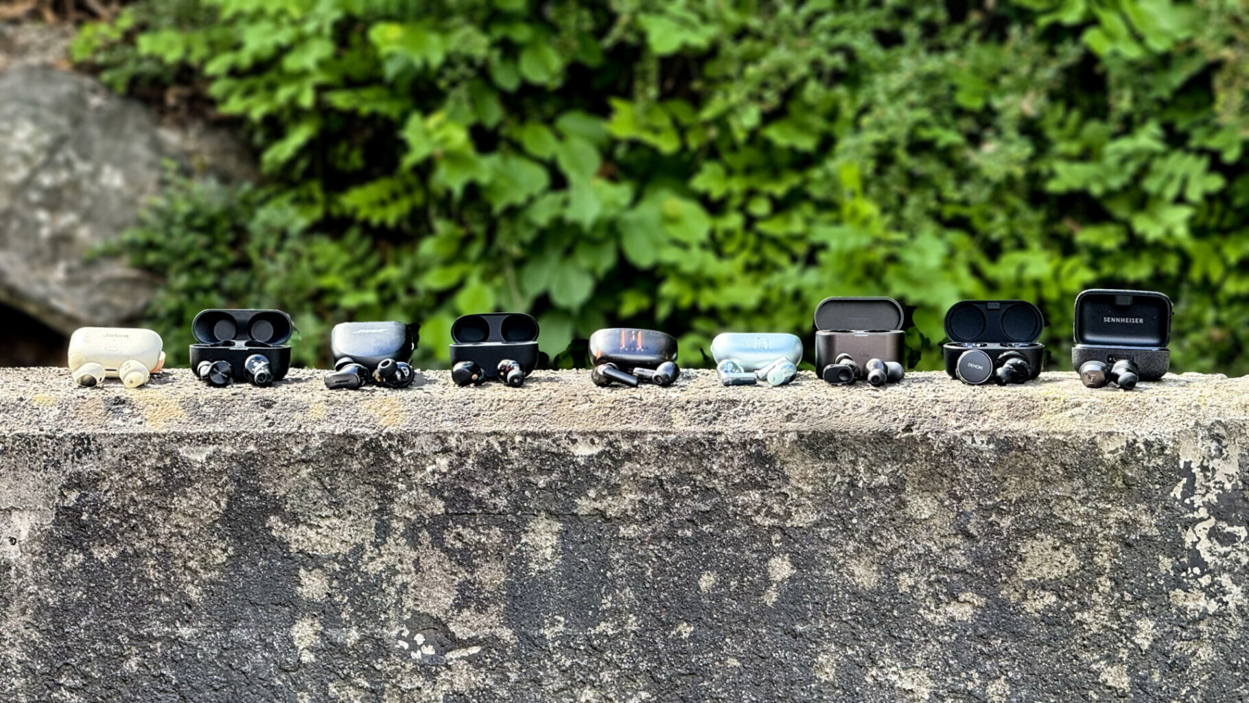 a group of premium true wireless earbuds on a concrete ledge ørepropper