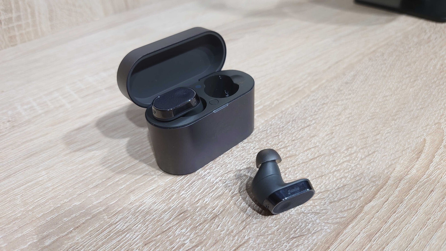 a black earbuds in a case Philips Fidelio T2